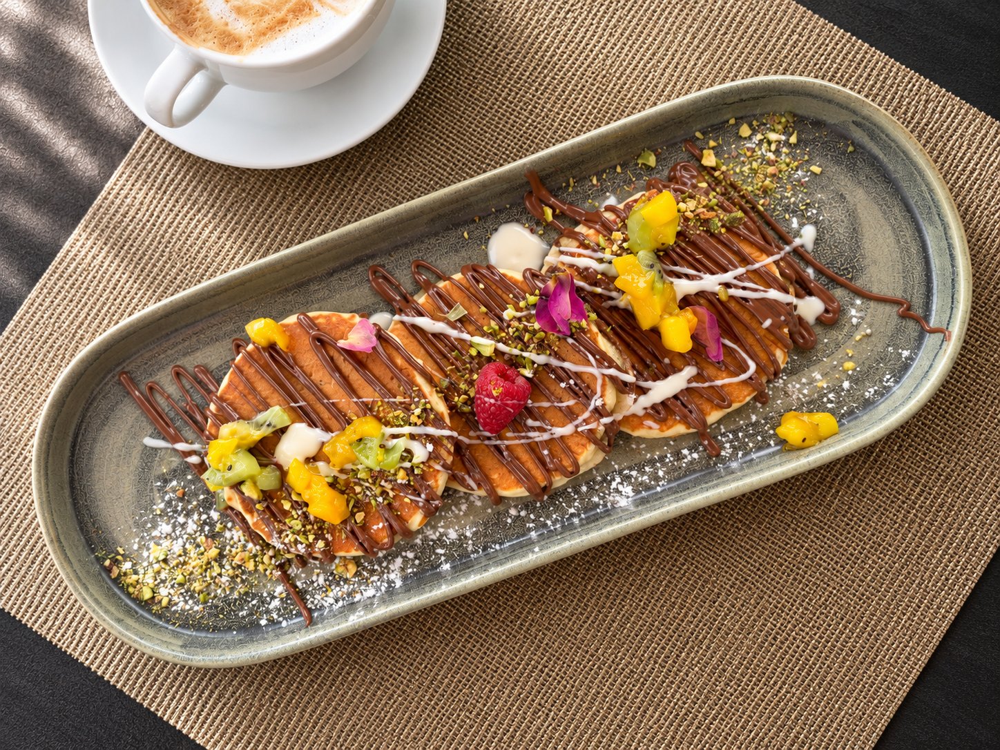 Douceur au chocolat et aux fruits servie sur un plat long, décorée de fleurs